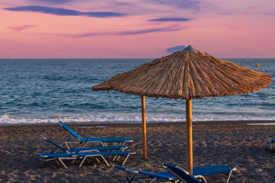 Coucher de soleil sur la plage de Cua Dai à Hoi An, l'une des plus belles plages du Vietnam, avec un rivage de sable noir avec des chaises longues et des parasols.