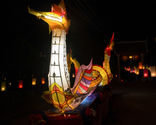 Bateau illuminé aux lanternes pendant le festival Awk Phansa