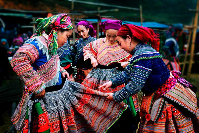 Des femmes H’Mong présentent des vestes brodées éclatantes au marché de Bac Ha, un chef-d’œuvre des vêtements ethniques de Sapa.