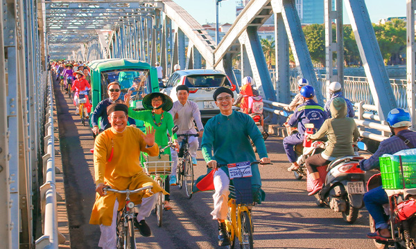 Défilé en ao dai traditionnel de Hué en cyclo-pousse et à vélo
