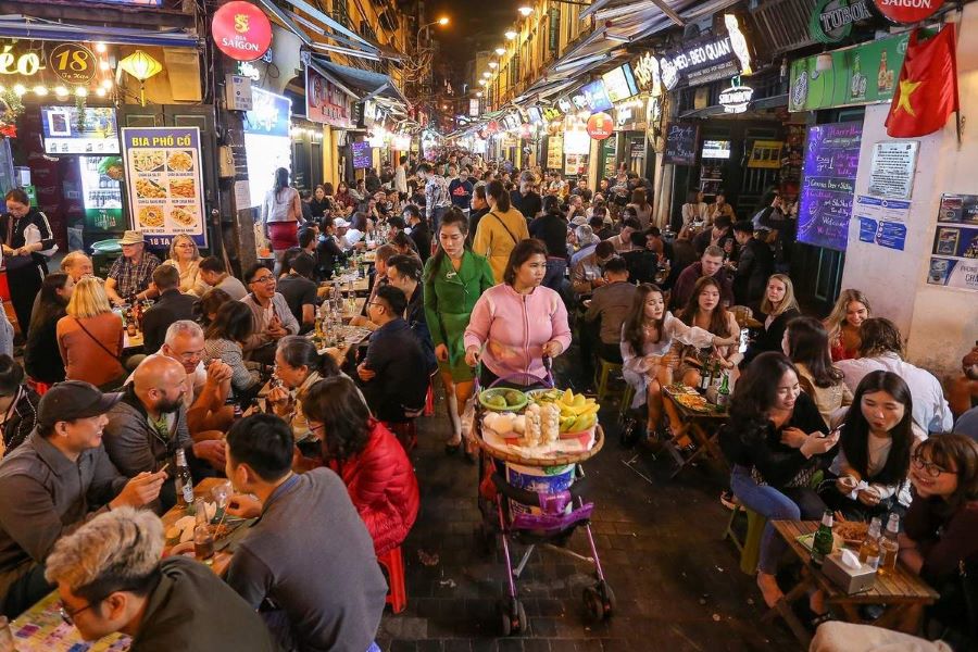 Rue Ta Hien à Hanoi la nuit, animée par des stands de bia hoi, une activité à Hanoi pour vivre l’énergie de la vie nocturne.